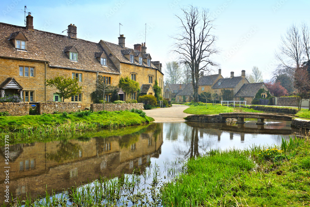 Cotswolds village of Lower Slaughter with beautiful morning reflections and bridge, England