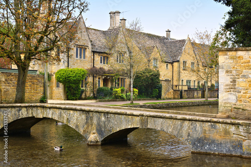 Idyllic Cotswolds village of Bourton on the Water with bridge and stone houses along the River Windrush, England photo