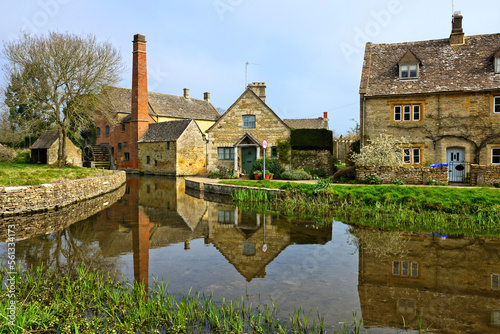 Cotswolds village of Lower Slaughter with beautiful morning reflections and old mill, England