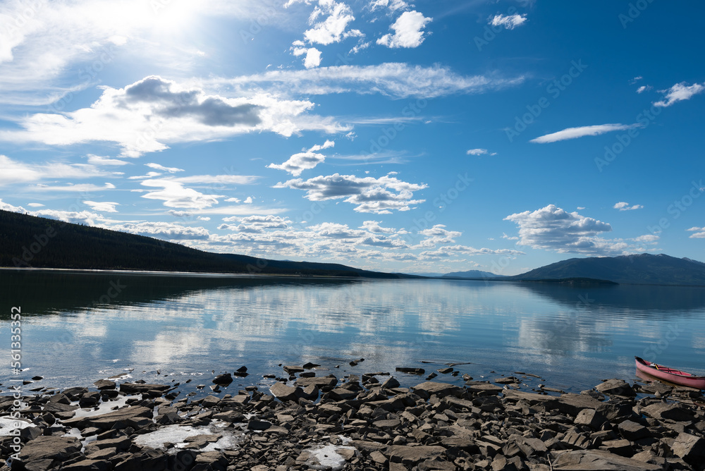 Sweeping panoramic views of wilderness area in Yukon Territory, Canada during summer with red canoe. Sweeping panoramic views of wilderness area in Yukon Territory, Canada during summer with red canoe.