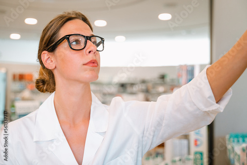 Woman working in the pharmacy looks for the medicine