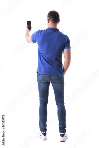 Rear view of modern adult casual man taking photo with smart phone. Full body isolated on transparent background.