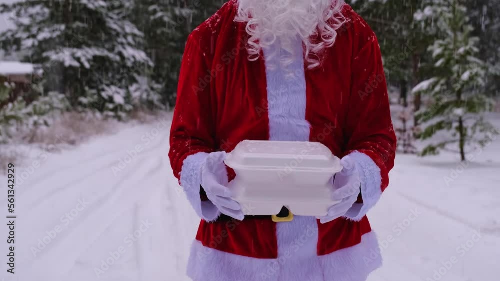 Food delivery service containers in hands of Santa Claus outdoor in snow. Christmas eve promotion. Ready-made hot order, disposable plastic box. New year holidays catering. Copy space, mock up Food delivery service containers in hands of Santa Claus outdoor in snow. Christmas eve promotion. Ready-made hot order, disposable plastic box. New year holidays catering. Copy space, mock up