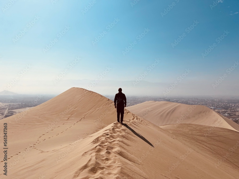 A man stopped on a dune in the desert. Huacachina, Peru