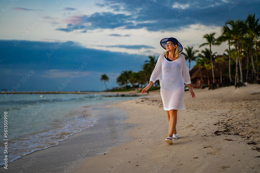 Woman walking on sunny, tropical beach at daybreak
Woman walking on sunny, tropical beach at daybreak