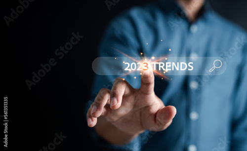 New business target start up in new years, Businessman using smartphone to input keyword of 2023 trends inside infographic searching engine bar for marketing, business planning change concept.