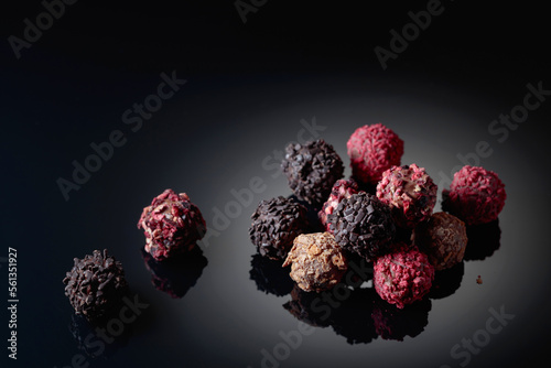 Chocolate candies on a black reflective background.