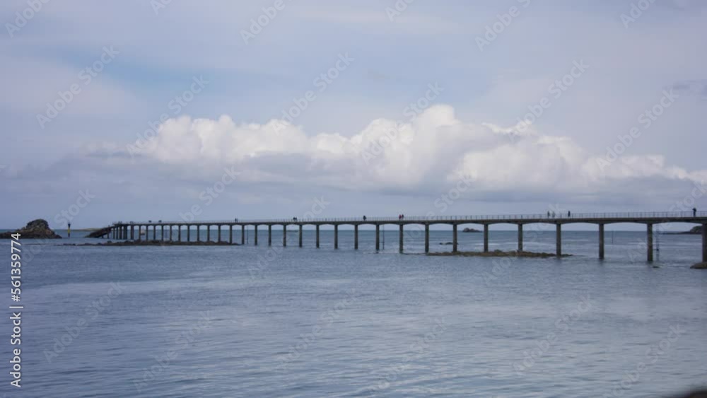 A huge pier on the ocean with people on it, in Britanny, France A huge pier on the ocean with people on it, in Britanny, France