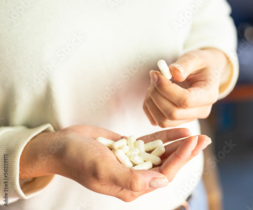 Woman holding white capsules in her hands, health care, drug dosage, supplementation