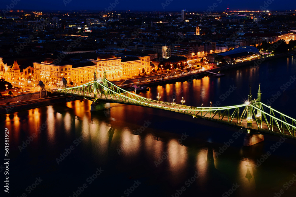 the Liberty bridge in Budapest. aerial evening view or blue hour. brightly illuminated steel structure. reflection on water. tourism and travel concept. transportation and design. night photo