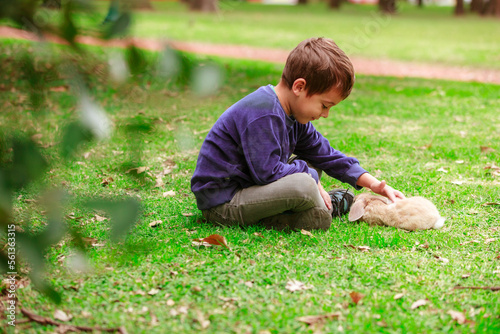 little boy with a rabbit in the park