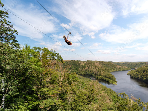 Person beim Ziplining vom Berg Richtung See ins Tal