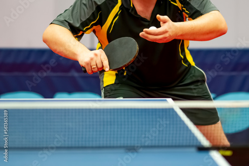 table tennis player serving, holding ball in his hand