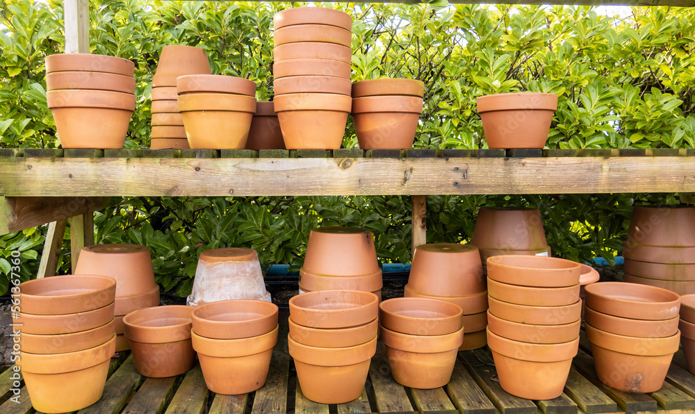 Stacks of various terracotta pots for plants for sale at a garden store. Stacks of various terracotta pots for plants for sale at a garden store.