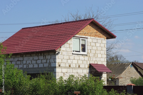 Wallpaper Mural white brick  private house with a window under a red tiled roof against a blue sky in the rural street Torontodigital.ca