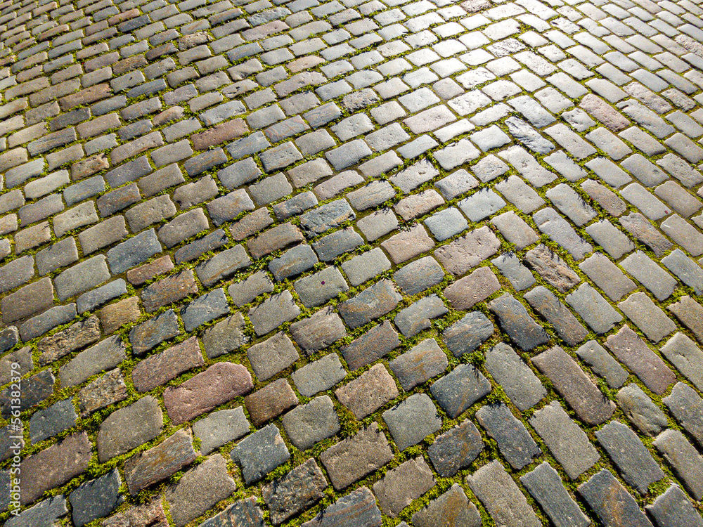 Granite dirty paving stones in the city. Road from paving stones for background and texture. The old road of granite paving stones