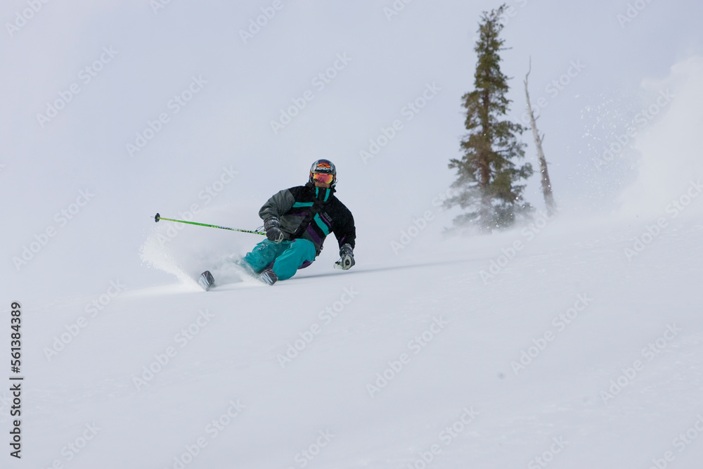 A skier descends a snowy slope through deep powder on a beautiful day in Kirkwood, California. A skier descends a snowy slope through deep powder on a beautiful day in Kirkwood, California.