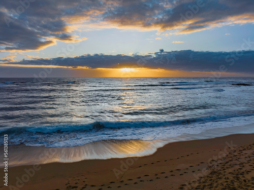 Sunrise over the ocean with clouds and sunburst