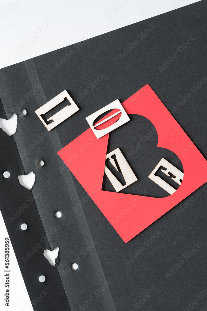 Obraz premium letters and heart frame on grungy and torn photo album paper