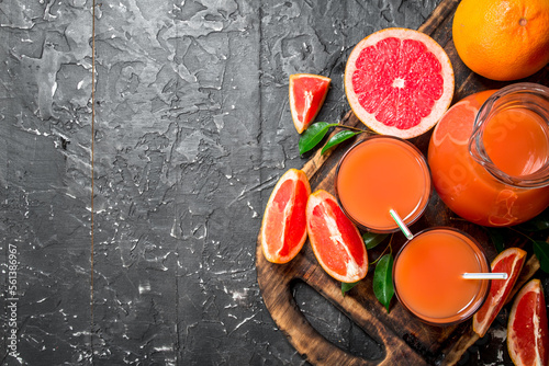 Juice of ripe grapefruit in a jug on a cutting Board.
