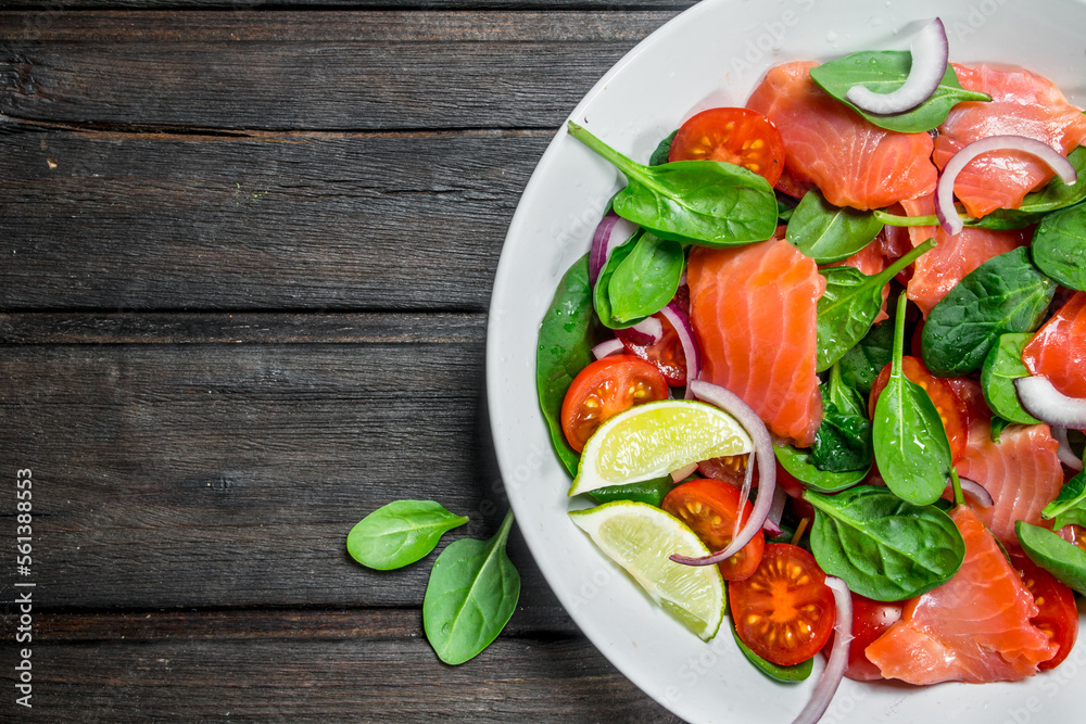 Fish salad. Salad with slices of salmon, tomatoes and spinach with lime juice. Fish salad. Salad with slices of salmon, tomatoes and spinach with lime juice.