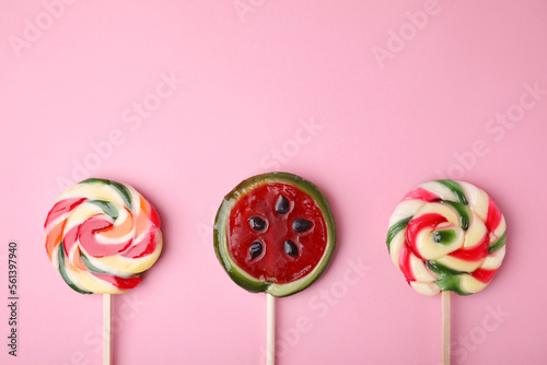 Different colorful lollipops on pink background, flat lay. Space for text