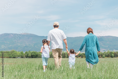 春・夏に公園・草原を歩く家族・ファミリーの後ろ姿（子供・両親・移住・田舎暮らし） photo