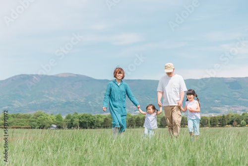 春・夏に公園・草原を歩く家族・ファミリー（子供・両親・移住・田舎暮らし） photo