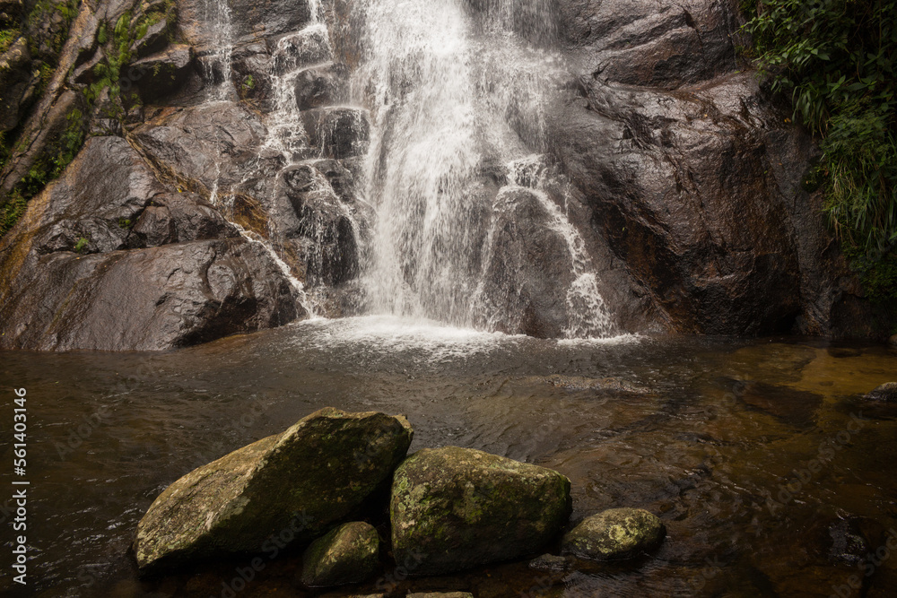 Naklejka premium Pedras da Cachoeira do Veloso - ILHABELA, SP, BRAZIL - DECEMBER 01, 2022: Stones in the well of the beautiful Veloso waterfall in the middle of the lush Atlantic forest.