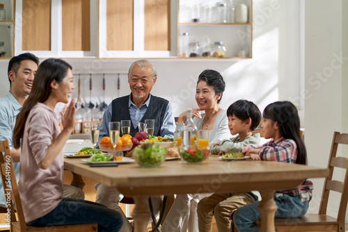asian family chatting while eating meal
