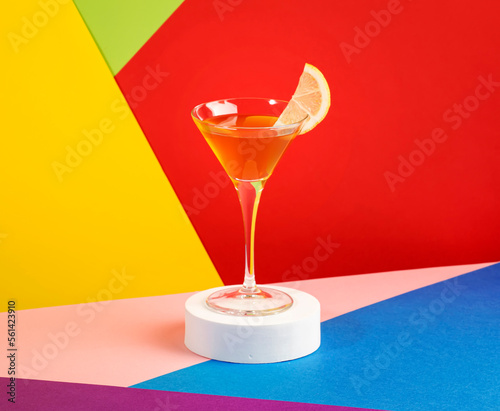 Yellow bird alcoholic cocktail with white rum, liquor and lime juice in martini glass. Modern style still life on bright multicolored background