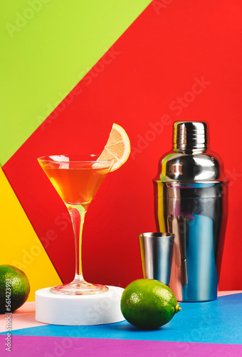 Yellow bird alcoholic cocktail with white rum, liquor and lime juice in martini glass. Modern style still life on bright multicolored background