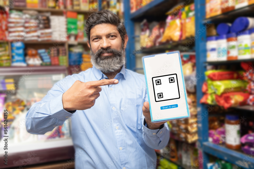 Portrait Of Happy Mature Indian Man Showing Qr Code Scanner To Pay portrait-of-happy-mature-indian-man-showing-qr-code-scanner-to-pay