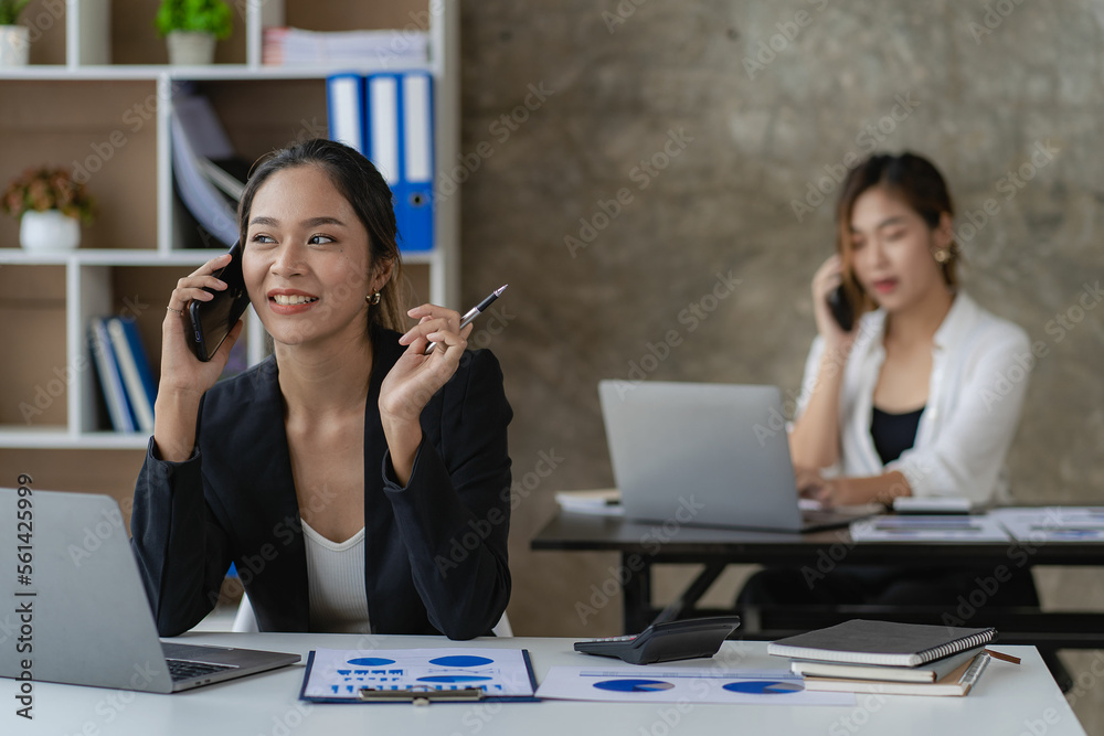 Two beautiful and attractive Asian businesswoman or female accountants work together in the office. teamwork concept Work on sales and financial reports. Two beautiful and attractive Asian businesswoman or female accountants work together in the office. teamwork concept Work on sales and financial reports.
