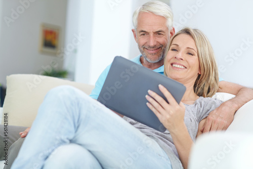 Mature couple, tablet or relax on sofa in house or home living room on social media or internet app. Happy smile, retirement man or woman on digital technology for video call, movie streaming or news © Reese/peopleimages.com