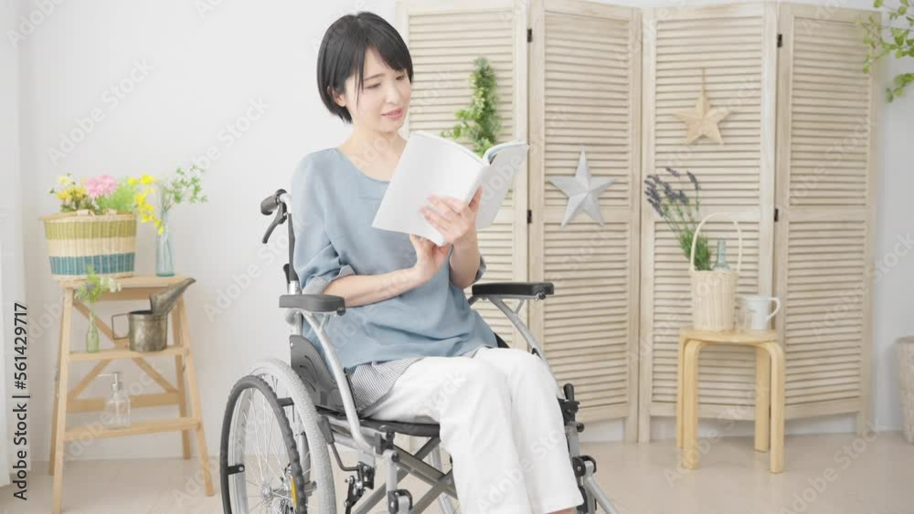 車椅子に座りながら本を読む若い女性 多様性社会イメージ 車椅子に座りながら本を読む若い女性 多様性社会イメージ