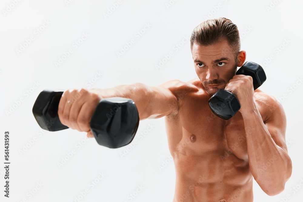Man athletic body bodybuilder posing with dumbbells with naked torso abs full-length in the background, fitness class. Advertising, sports, active lifestyle, competition, challenge concept. Man athletic body bodybuilder posing with dumbbells with naked torso abs full-length in the background, fitness class. Advertising, sports, active lifestyle, competition, challenge concept.