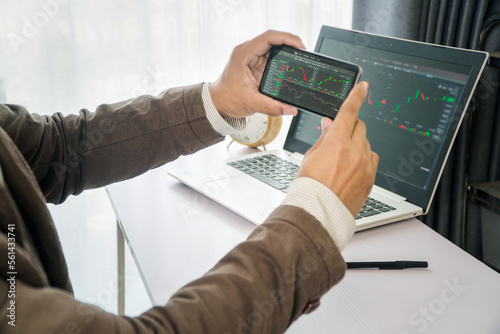 Bussiness man hand holding smartphone to take a screenshot of data from latop screen for data breach cyber crime concept