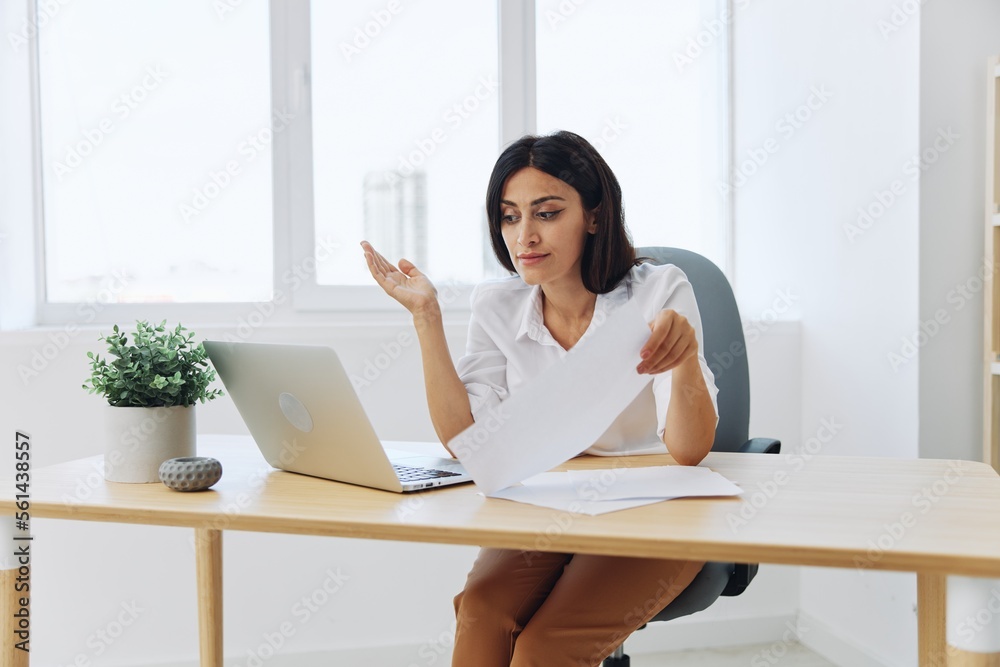 Obraz premium Woman business works at her laptop at home in her office, freelance employee in business, problems with work and paperwork