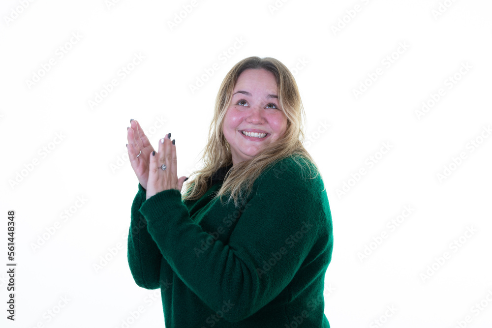 Happy plus size applauds hands woman body positive attractive overweight girl looking up side on white background in green sweater