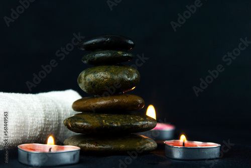 Layers of hot stones use for massage setting lit by candles light and Massage therapy for wallper, pattern, poster and banner design..