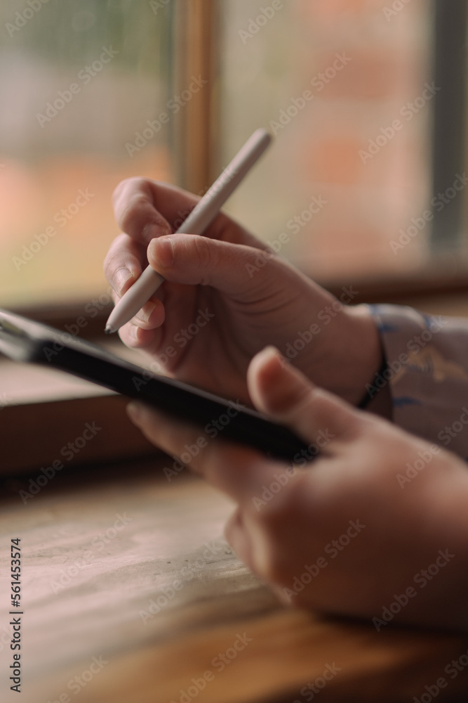 S. setting goals on a tablet while working at a café. S. setting goals on a tablet while working at a café.