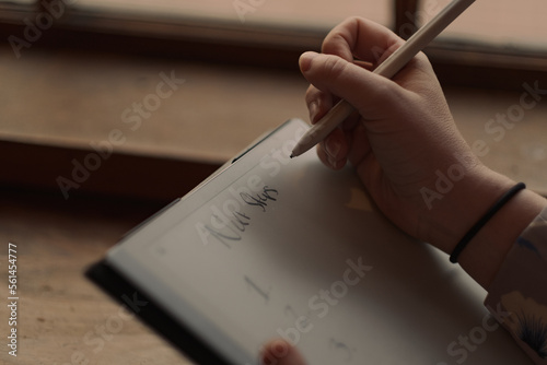 S. setting goals on a tablet while working at a café.