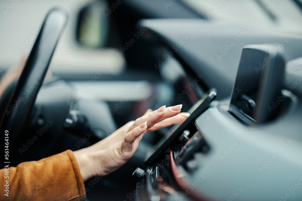 Close up of a female's hand properly using phone in a car. Close up of a female's hand properly using phone in a car.