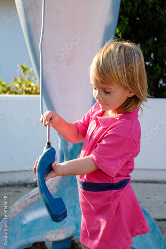 little child plays with a handset from an old telephone box
