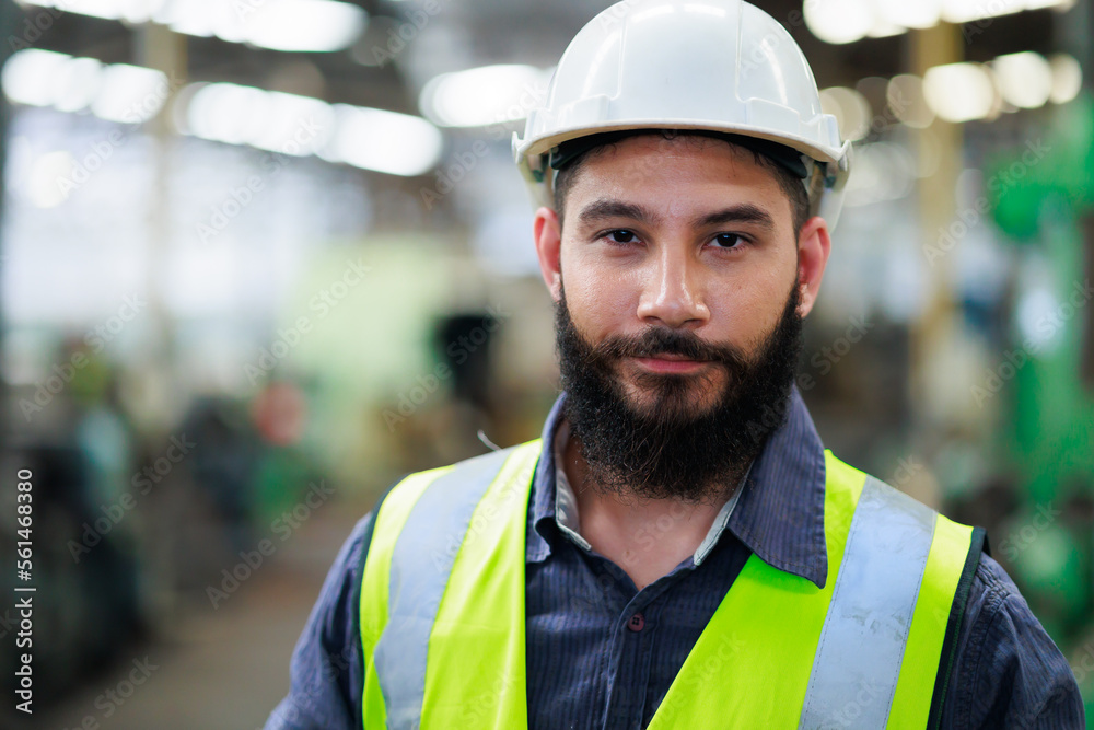 Portrait Professional mechanical engineering hispanic male in white safety hard hat helmet and look at camera at metal factory.