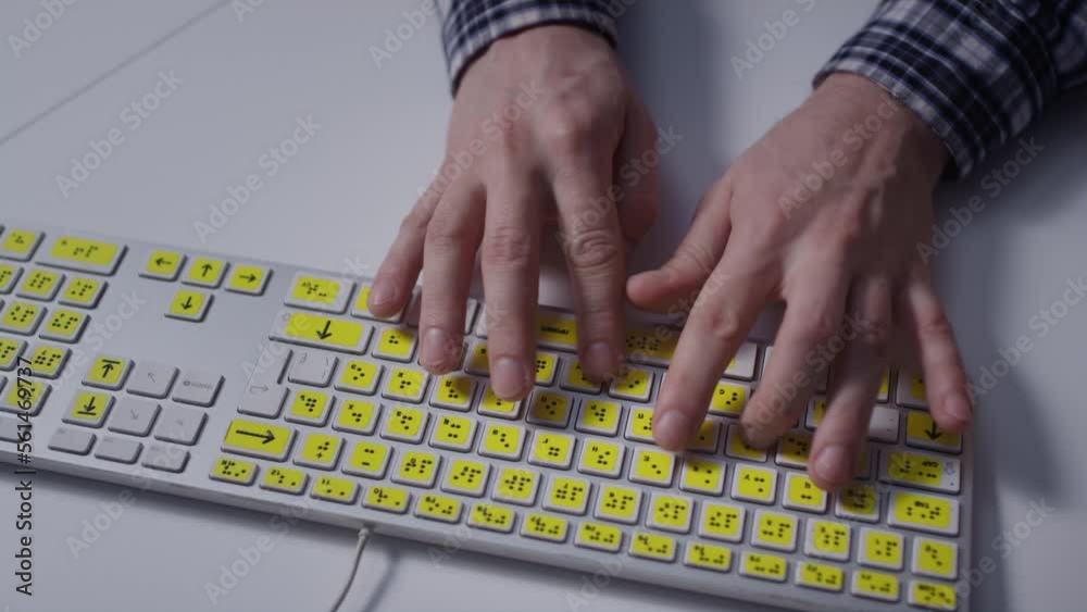 Close-up: A man uses a keyboard with braille.A blind man is typing words on the buttons with her hands. Technological device for visually impaired people. Tactilely touches bumps on the keys Close-up: A man uses a keyboard with braille.A blind man is typing words on the buttons with her hands. Technological device for visually impaired people. Tactilely touches bumps on the keys