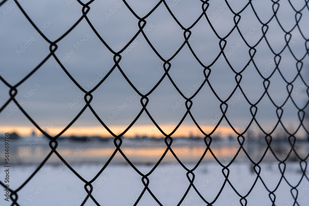 Background of metal fence with sunrise in background over cityscape Background of metal fence with sunrise in background over cityscape