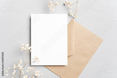 Blank wedding invitation card mockup with envelope and dried flowers. Flat lay, top view, copy space