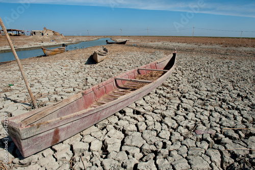 Canvastavla A traditional Marsh Arab canoe known as a Mashoof abandoned on the dry cracked earth of the southern marshes of Iraq during a hash summer drought